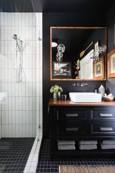 black bathroom with wood countertop