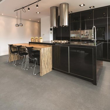 kitchen space with black cabinets and gray cork flooring