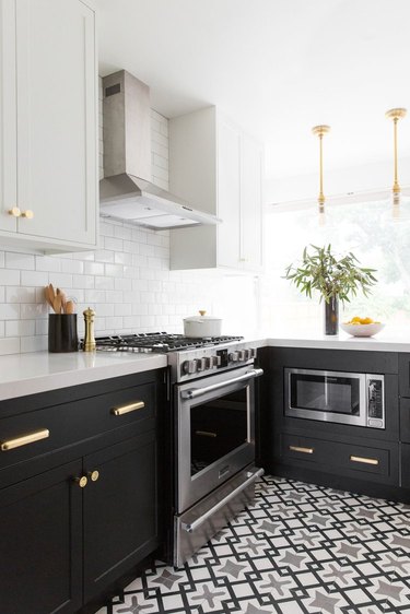 two-tone kitchen cabinets with black and white and brass hardware