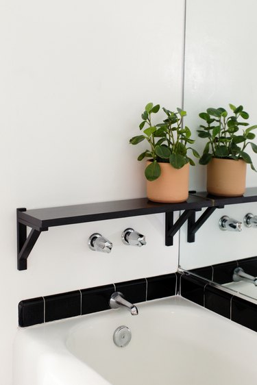 bathroom backsplash idea with black subway tile around white bathtub