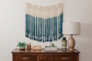 White and blue macrame art hanging on wall.