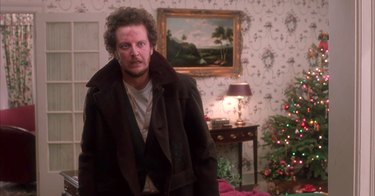 burglar stands in christmas living room, still image from home alone set