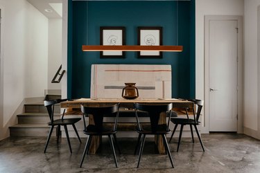 dining room with concrete floor and teal accent wall