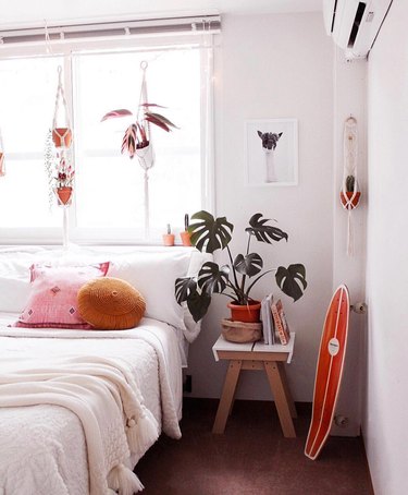 white bedroom with pops of orange decor