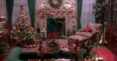 young boy hanging christmas stocking in living room, still image from home alone set