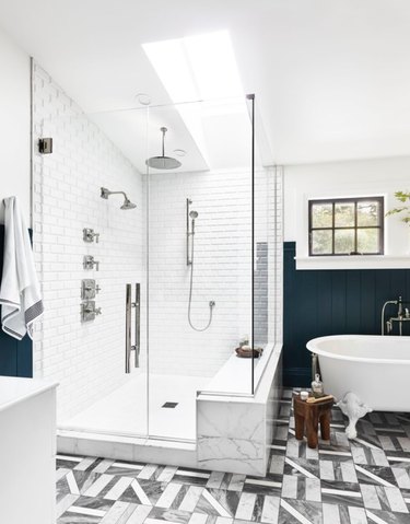 Grey and white geometric floor tile and white tiled shower in bathroom designed by Emily Henderson.