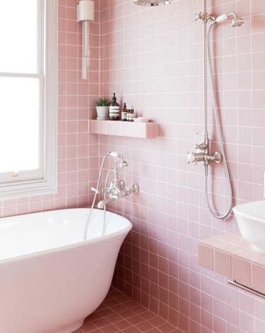 Pink square tile in shower with white bath tub.