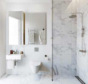 white bathroom with marble shower and flooring