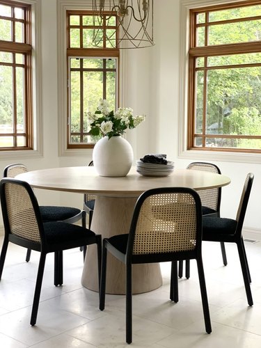 minimal dining room table centerpiece with round table and cane chairs