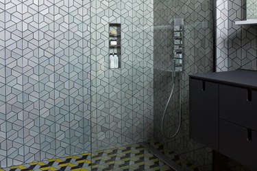 Hexagon tiling in master shower with gunmetal, black, and yellow colors.