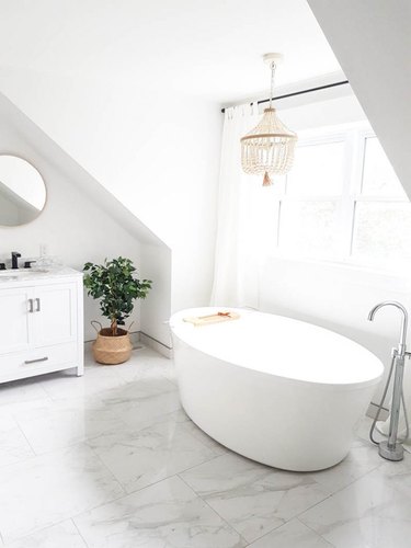 white bathroom with marble flooring and freestanding tub