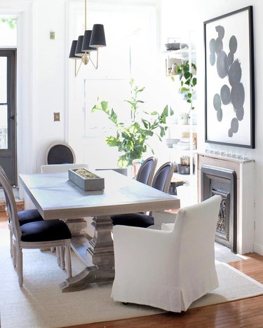 dining room table centerpiece with slipcovered chairs with black french louis dining chairs in neutral dining room