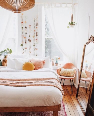 bedroom with peach accents and flowers hanging on the wall