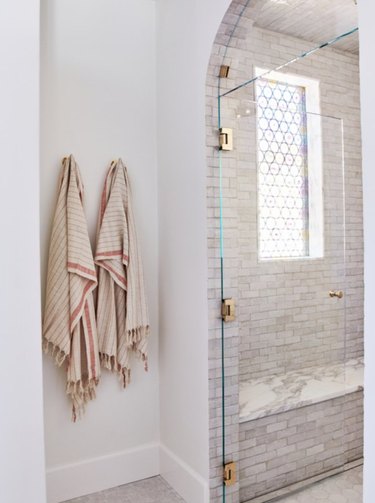 An alcove shower with frameless door shows off it's tile work.
