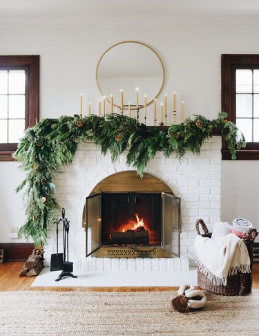 rustic white fireplace with wood panels and brass detailing