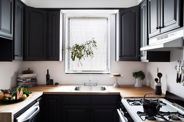 wood IKEA countertops in kitchen with black cabinets
