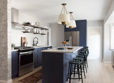 navy blue kitchen color idea with cabinets and island and black stools