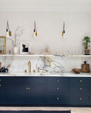 navy blue kitchen color idea with blue cabinets and marble countertop and backsplash
