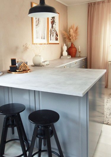 marble-inspired laminate IKEA countertop in kitchen with blue cabinets
