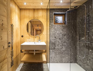 rustic shower idea with stone tile walls that balance the wood walls and ceiling