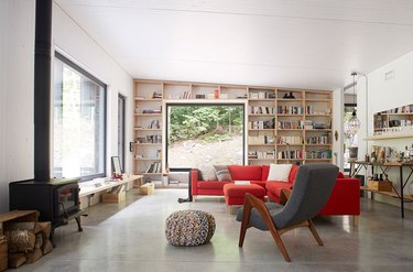 contemporary living room with bookshelves, big windows and wood stove fireplace