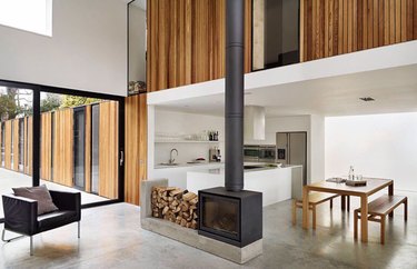 modern minimal living room and dining room with wood stove fireplace
