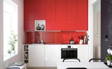 Glossy red painted kitchen cabinets with white lover cabinets.