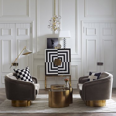 two gray chairs with gold bottoms and gold coffee table