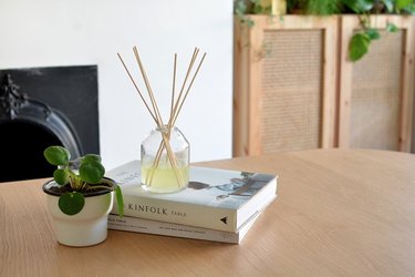 Reed diffuser on table with books.