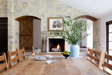 rustic dining room with stone fireplace and farmhouse table