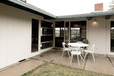 outdoor area with white table and four white chairs