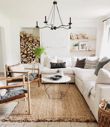 rustic living room idea with iron chandelier and stacked wood logs