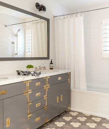 shower window idea with shutters and campaign bathroom vanity with brass hardware
