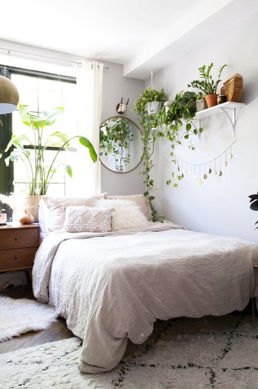 Boho bedroom with plants and white shag rug.