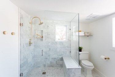 shower window idea in brass and marble bathroom with shower seat and shower window