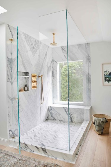 shower window idea in marble and brass bathroom with oversized shower window