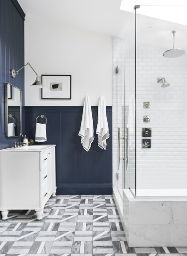 chrome rain showerhead in white and blue bathroom