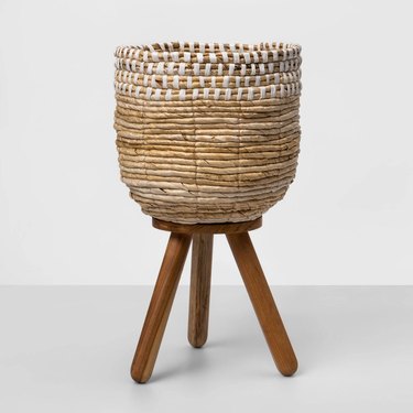 natural and white woven planter on wood stand