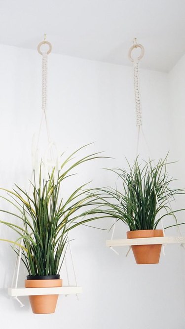 Pair of small hanging macrame planter holders with blonde wood base