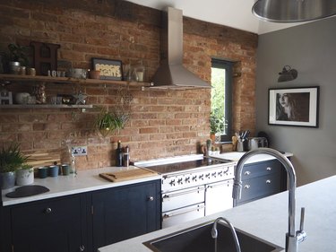 navy blue kitchen with brick backsplash