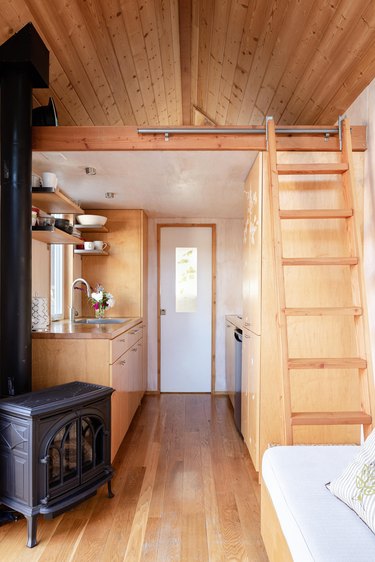 Sol Haus Design tiny home living area with ladder to bed