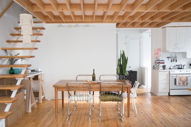 dining room with wood floors, open staircase, wood table, kitchen