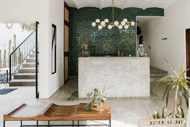 open entryway space leading to outdoors with concrete floors, tiled wall, scalloped ceiling