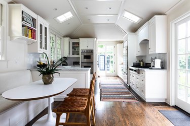 galley kitchen with arched ceilings and small dining area