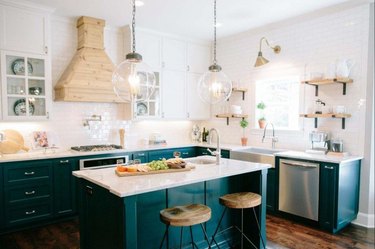 Craftsman kitchen with green cabinets and white subway tile walls