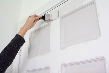 Hand painting white door with paintbrush