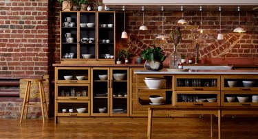 kitchen space with wood cabinets and brick wall