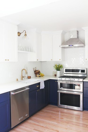 White and navy blue kitchen color idea with silver appliances and white tile backsplash