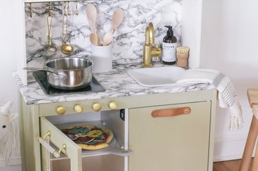 Add modern glam to the IKEA Duktig play kitchen with marble and brass accents.