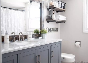 small farmhouse bathroom idea with gray cabinets and rustic mirror